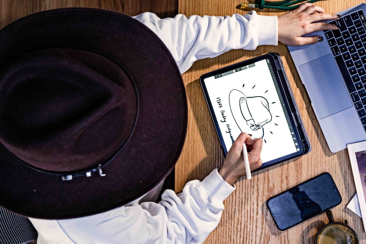 Hat design and development workspace with drawings, materials and sample hats